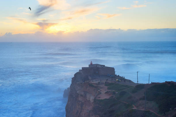 Nazare lighthouse sunset ocean Australia Famous Nazare lighthouse at sunset. Nazare, Portugal nazare surf stock pictures, royalty-free photos & images
