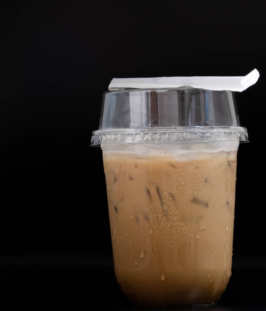 iced coffee milkshake straw on a plastic glass and have water droplets adhering to the glass - adhering imagens e fotografias de stock