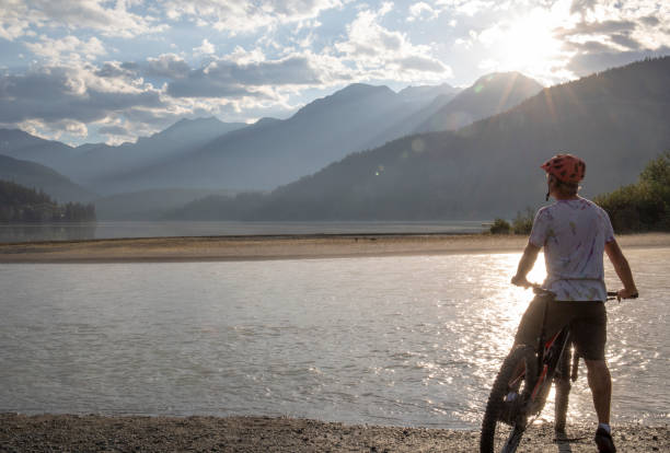 istock Mountain biker relaxes by lakeshore at sunrise 1279950731