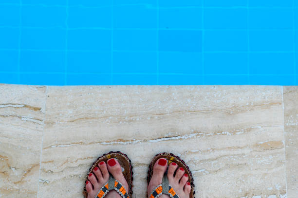 pieds de femmes en pantoufles sur le bord de la piscine. - historical reenactment fun heat recreational pursuit photos et images de collection