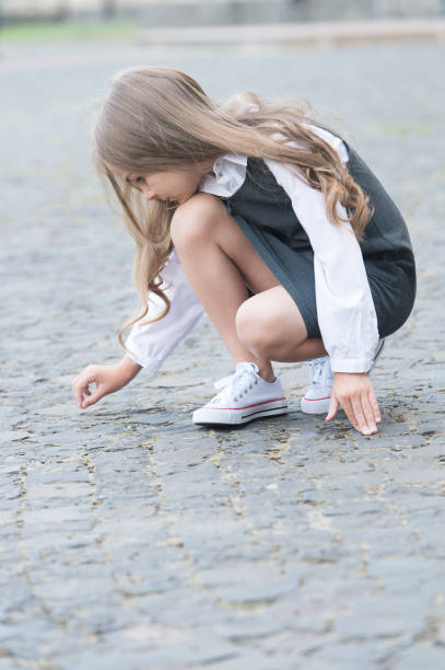 istock Learning before playing. Little child draw on pavement outdoors. Back to school fashion. Uniform dress. Early childhood education. Playschool and afterschool. Educational games. Playing time 1279952541