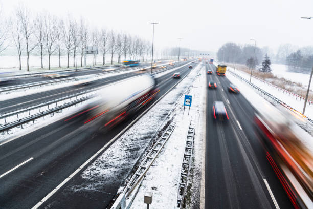 istock Moving traffic on a highway during a snow blizzard in winter 1279952573