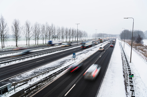 Traffic on a highway during a snow blizzard in winter near Zwolle in Overijssel, The Netherlands.