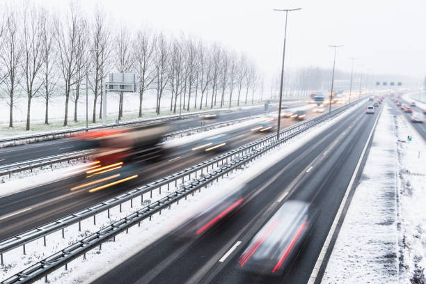 istock Moving traffic on a highway during a snow blizzard in winter 1279952628