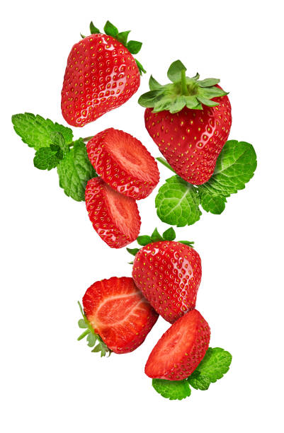 istock Falling strawberries with mint leaves isolated over white background. Whole, cut in half and sliced. Close up, copy space 1279952658