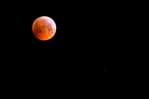 The super blood wolf moon lunar eclipse in the dark night sky.