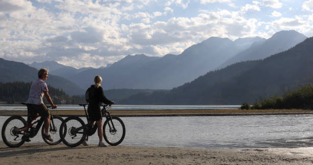 istock Couple on e-bikes relax by lakeshore at sunrise 1279953629