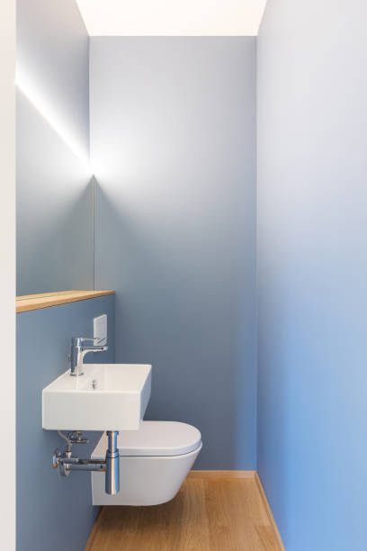 istock Front view of modern light blue bathroom with sink, mirror and led light 1279953796
