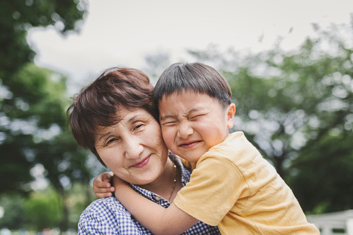 Asian grandmother and her grandson relaxed in the park.