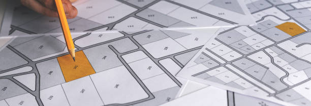 istock hand with pencil on cadastral map - choose and buy a building plot for house construction. banner copy space 1279961144