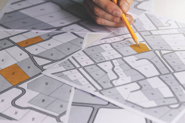 istock hand with pencil on cadastral map - choose and buy a building plot for house construction 1279961158