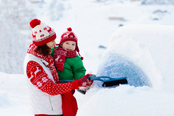 istock Mother and child brushing off car in winter. 1279962321