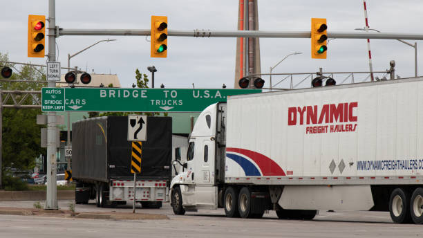 Transport Trucks Drive Under a "Bridge to USA" Sign in Windsor Ontario stock photo