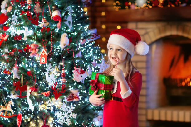 istock Child at Christmas tree and fireplace on Xmas eve 1279962438