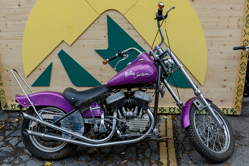 Uzhgorod, Ukraine - September 27, 2020: Pink retro motorcycle near a wooden fence during an exhibition of vintage motorcycles.