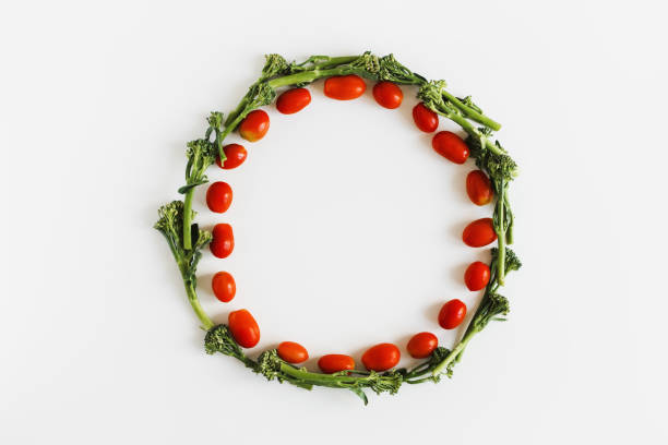 istock Cherry tomato and broccoli florets wreath on white background, top view. Plant based diet concept 1279963923