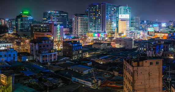Warm street lights glowing between the crowded rooftops of this low rise area of central Seoul, South Korea’s vibrant capital city.