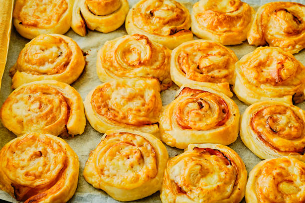 istock Fresh tasty puff pastry rolls  with ham and cheese on baking tray top view 1279970633
