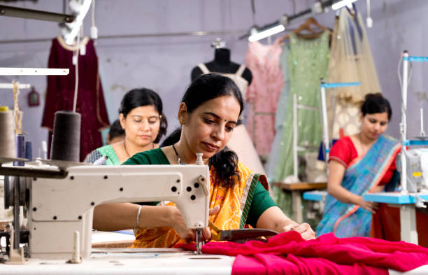 indian woman textile worker cutting dress fabric on production line - factory garment sewing textile imagens e fotografias de stock