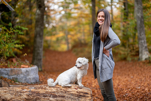 Young woman walking a dog in the woods