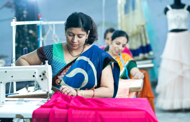 mujer india trabajador textil corte tela de vestir en la línea de producción - garment factory fotografías e imágenes de stock