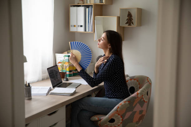 istock Overheated young pretty woman using paper fan. 1279977896