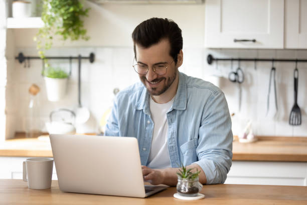 istock Smiling young guy in glasses enjoying online communication. 1279978026