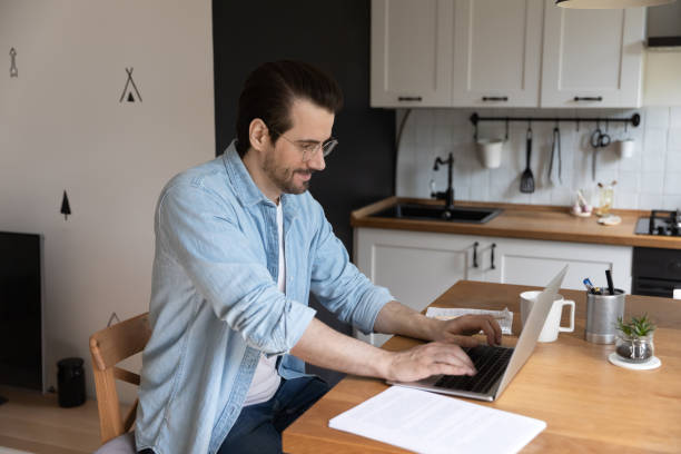 istock Smiling millennial businessman working distantly at home office. 1279978034