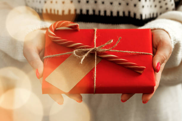 istock Female hands in sweater holding wrapped Christmas gift 1279978567