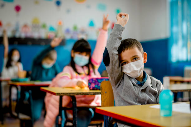 istock Elementary schoolchildren wearing a protective face masks  in the classroom. Education during epidemic. 1279979888