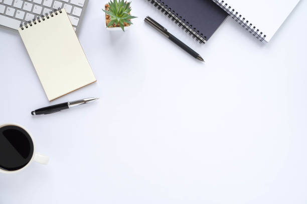 istock Top view above of White office desk table with keyboard, notebook and coffee cup with equipment office supplies. Business and finance concept. Workplace, Flat lay with blank copy space. 1279980578