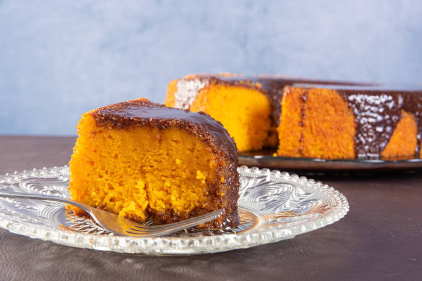 Carrot cake with chocolate icing on a glass plate on a table, selective focus. Carrot cake with chocolate icing on a glass plate on a table, selective focus. carrot cake stock pictures, royalty-free photos & images