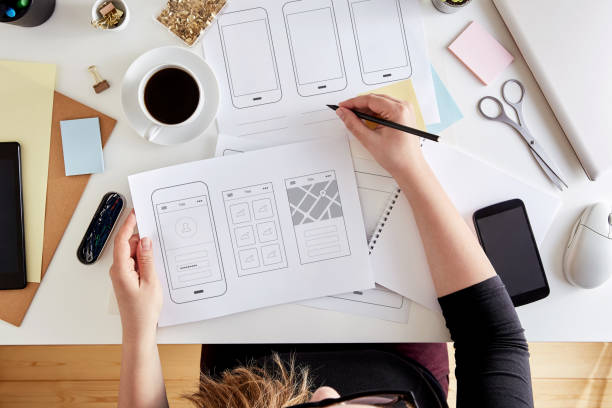 User experience concept Top view of young UX graphic designer planning out the structure of a mobile application. Wireframing stage of a web mobile phone. Flat lay website wireframe photos stock pictures, royalty-free photos & images