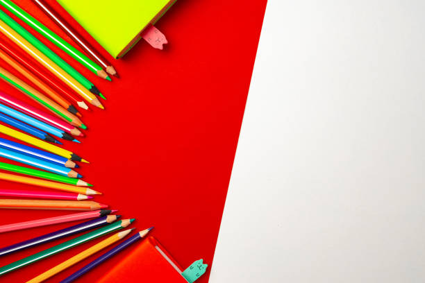 istock Colorful pencils and notepads on paper background top view 1279985476
