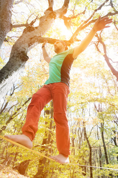 istock A bearded man in age walks along a slackline stretched in an autumn forest. Active recreation for middle-aged people 1279985904
