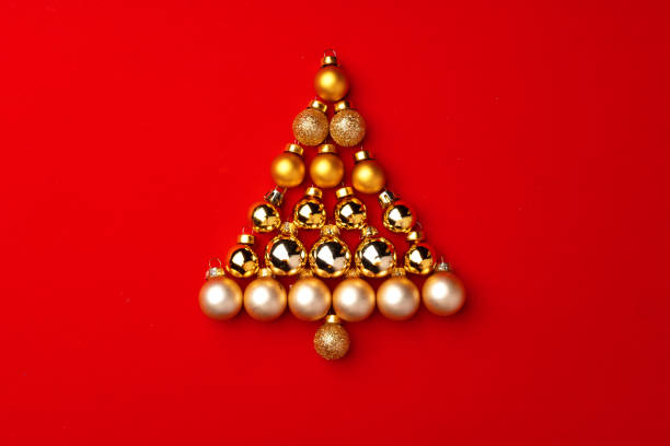 istock Christmas tree made of gold baubles on red background 1279986551