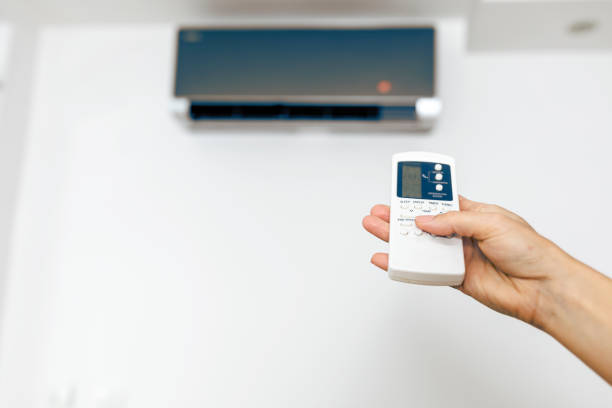 istock Hand hold remote control directed on the air conditioner 1279986574