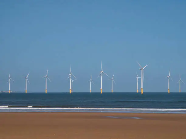 Wind turbines of the offshore Redcar / Teeside Wind Farm, located on the north east coast of England in the UK - taken on a sunny day with a blue sky at the end of summer.