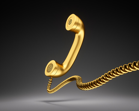 Gold Telephone Receiver on dark Background