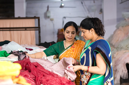 Two woman textile worker checking garment stock at factory