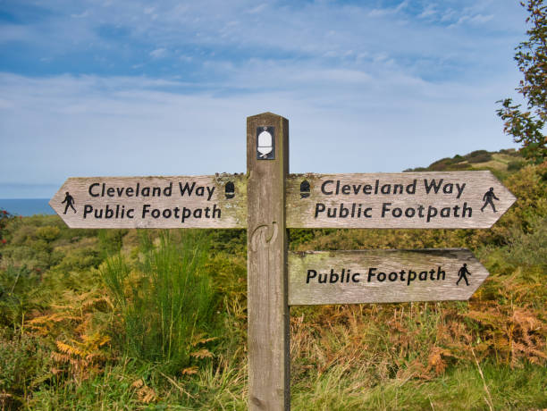 A wooden signpost on a coastal section of the Cleveland Way national trail between Robin Hood's Bay and Ravenscar in North Yorkshire, England, UK - taken on a sunny day A wooden signpost on a coastal section of the Cleveland Way national trail between Robin Hood's Bay and Ravenscar in North Yorkshire, England, UK - taken on a sunny day cleveland england stock pictures, royalty-free photos & images