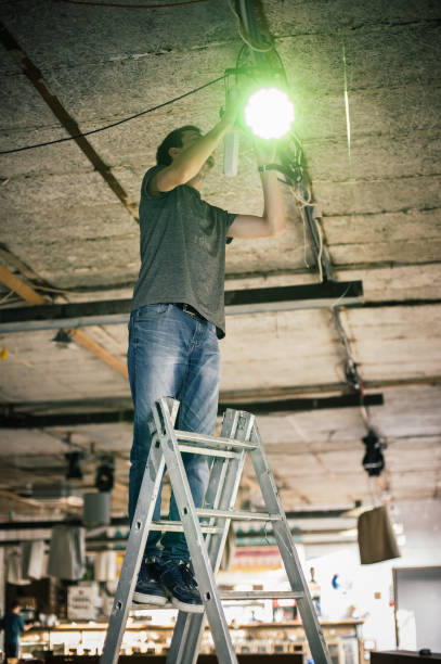 istock Behind the scene. Lighting technician electric engineer adjusting stage lights 1279992639