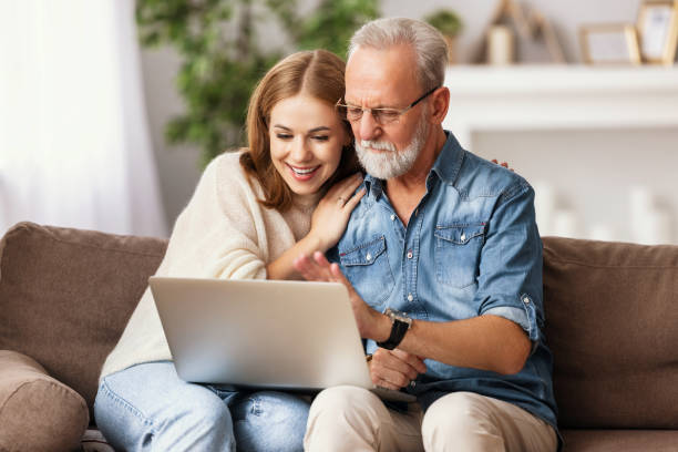 istock Young woman with father using laptop at home 1279992767