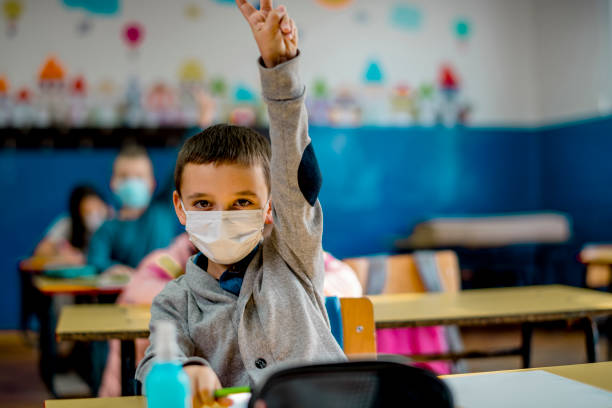 istock Elementary schoolchildren wearing a protective face masks  in the classroom. Education during epidemic. 1279992821