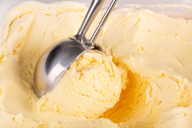 Vanilla ice cream being balled up by a scoop stock photo