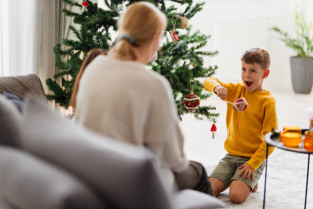 istock Mom and son playing beside Christmas tree 1279996644