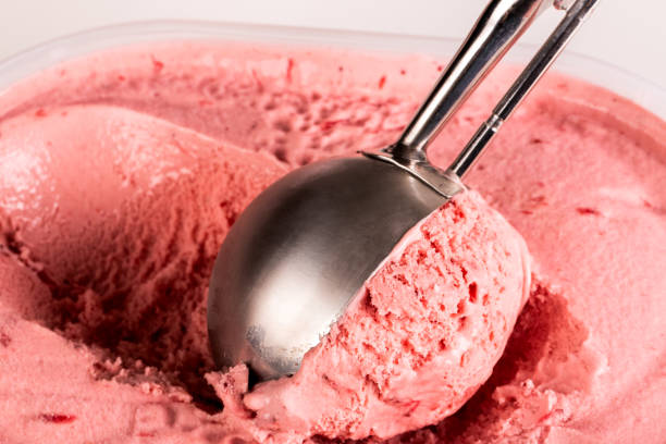 Close up of strawberry ice cream being scooped up stock photo