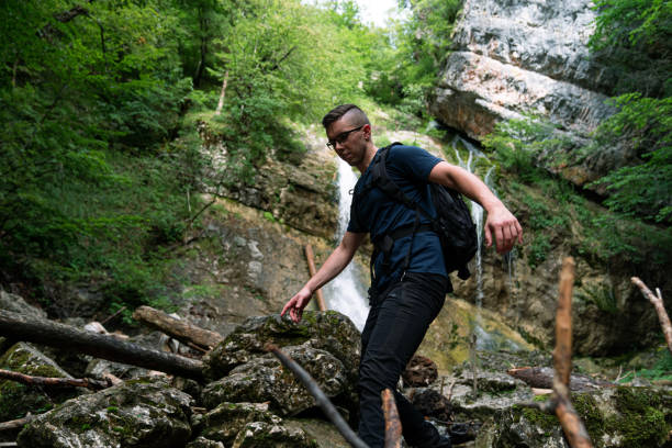 istock Young Caucasian man walking over rocks and branches 1279998799