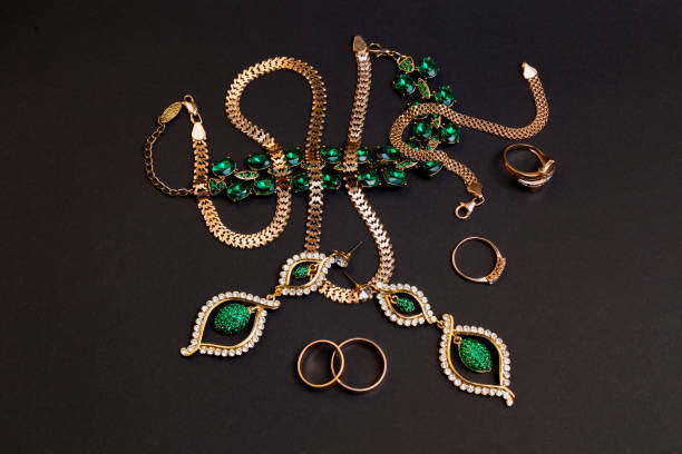 istock Gold jewelry with green stones on black 1279999325