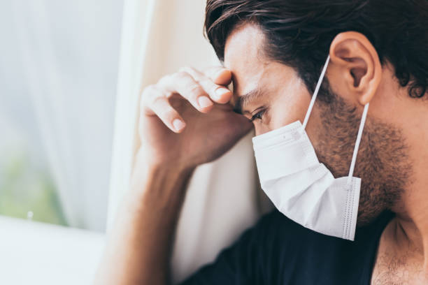 chateado deprimido melancólico triste chorando homem em máscara facial protetora com choro durante doença grave, surto de coronavírus e epidemia de gripe covid19. paciente fica no hospital, fica estressado, solitário - men mental illness loss despair - fotografias e filmes do acervo